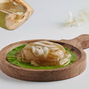 Coconut with a wooden spoon and coconut oil on a leaf